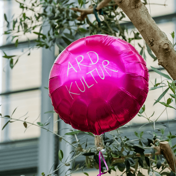 Helium-Ballon in Fuchsia-Farbe mit dem Schriftzug ARD Kultur.