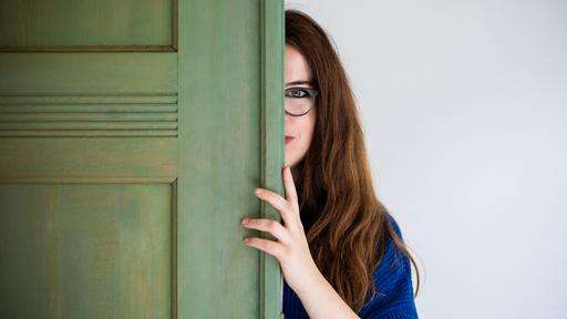 Eine Frau schaut hinter eine Tür hervor. Davor die Aufschrift: "Deep Dialog".