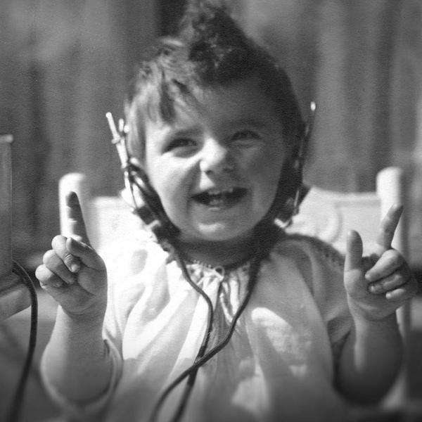 Kleines Kind mit Kopfhöhrern neben Radioempfänger