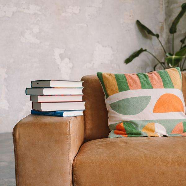 Ein Stapel Bücher liegt auf einem Sofa