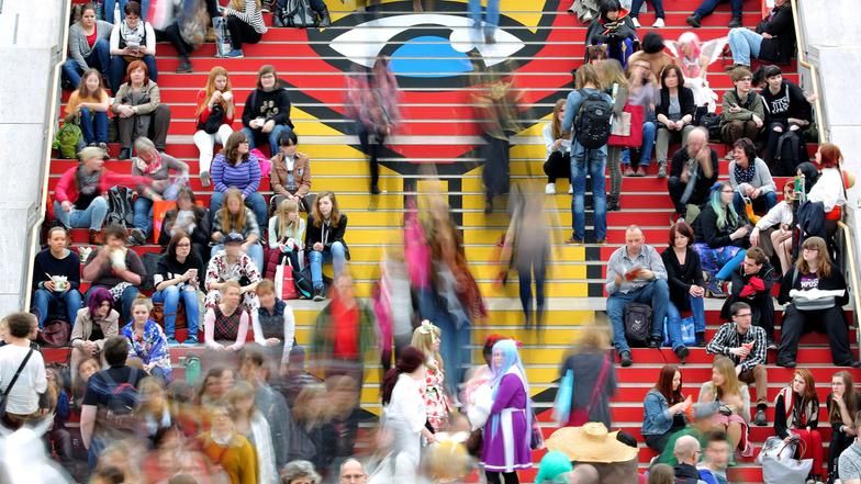 Besucher der Leipziger Buchmesse auf einer Treppe in der Glashalle