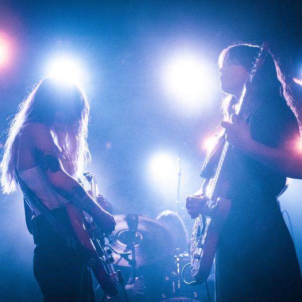 Zwei Frauen machen Musik auf einer Bühne in buntem Licht.