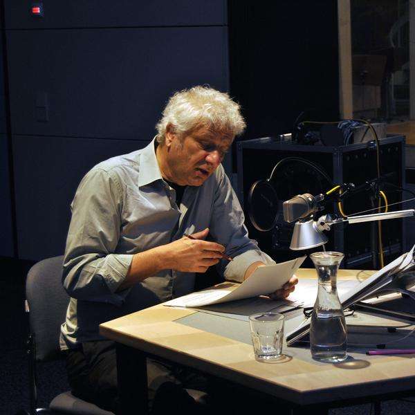 Schauspieler und Erzähler der Hörbiografie berühmter Komponist:innen: Udo Wachtveitl, mit weißen Haaren, blauem Hemd im Aufnahmestudio.