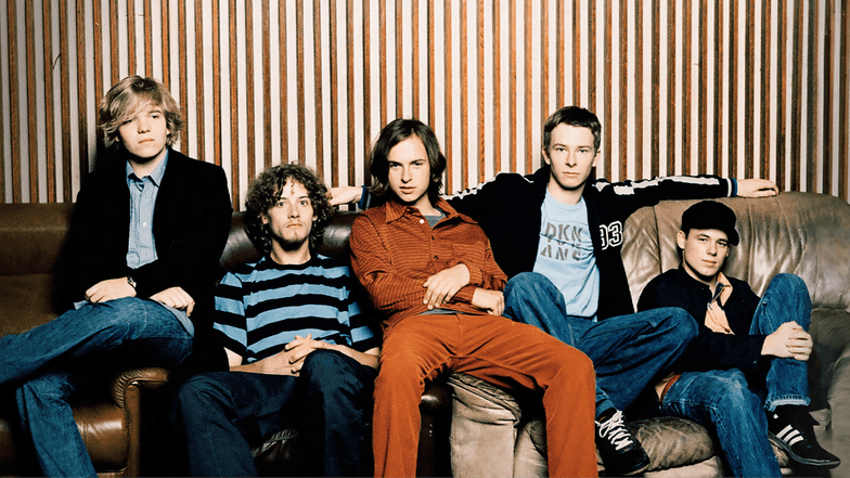 Fünf junge Männer sitzen auf einem Sofa.